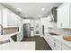 Modern kitchen with stainless steel appliances, white cabinetry, and quartz countertops at 13924 Jomatt Loop, Winter Garden, FL 34787