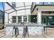 Stylish outdoor kitchen with a grill, sink, and bar seating, perfect for alfresco dining at 13924 Jomatt Loop, Winter Garden, FL 34787