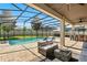 Inviting screened-in patio featuring a sparkling pool, comfortable seating, and outdoor bar at 13924 Jomatt Loop, Winter Garden, FL 34787