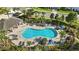 Aerial shot of the community pool featuring lounge chairs, a covered pavilion, and tropical palm trees at 13924 Jomatt Loop, Winter Garden, FL 34787