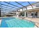 Beautiful screened-in pool area with outdoor kitchen, bar, and living area, ideal for entertaining guests at 13924 Jomatt Loop, Winter Garden, FL 34787