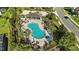 Stunning aerial view of a community pool surrounded by lush landscaping and ample seating areas at 13924 Jomatt Loop, Winter Garden, FL 34787