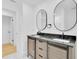 Stylish bathroom features double sinks, granite counters, and stylish round mirrors at 1484 Lake Francis Dr, Apopka, FL 32712