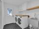 Functional laundry room with modern washer and dryer units, storage cabinets, and a convenient utility sink at 1484 Lake Francis Dr, Apopka, FL 32712