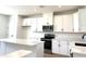 Well-lit kitchen boasts white cabinets, stainless appliances, and a functional kitchen island at 15125 Grove Lake Dr, Winter Garden, FL 34787