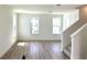 Open living area with wood floors, bright windows, and stairway access at 15125 Grove Lake Dr, Winter Garden, FL 34787