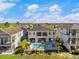 Aerial view of a beautiful backyard with a sparkling pool, palm trees, and ample seating areas for entertaining at 1526 Euston Dr, Reunion, FL 34747