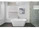 Bright bathroom featuring a freestanding tub, modern chandelier and a marble tiled glass-enclosed shower at 1526 Euston Dr, Reunion, FL 34747