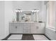 A luxurious bathroom featuring dual sinks, expansive mirror, and neutral tones throughout at 1526 Euston Dr, Reunion, FL 34747