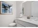 Bright bathroom with a white vanity, marble countertop, framed palm tree art and modern fixtures at 1526 Euston Dr, Reunion, FL 34747