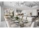Elegant dining area with a large table, seating for fourteen, modern lighting, and an open layout connecting to the living room at 1526 Euston Dr, Reunion, FL 34747