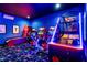 Brightly illuminated blue and red game room with arcade games and star patterned carpet, great for entertaining at 1526 Euston Dr, Reunion, FL 34747