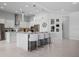 Well-lit kitchen with white cabinets, quartz countertops, a large island with seating and modern pendant lights at 1526 Euston Dr, Reunion, FL 34747
