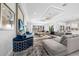 Open-concept living room featuring stylish furnishings, large windows, recessed ceiling with fan, and seamless flow to the kitchen at 1526 Euston Dr, Reunion, FL 34747