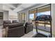 Well-lit living room features comfortable seating and a treadmill overlooking the balcony and scenic views at 1526 Euston Dr, Reunion, FL 34747