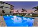 An inviting pool with lounge chairs and illuminated water, offering a relaxing outdoor retreat during a stunning sunset at 1526 Euston Dr, Reunion, FL 34747