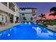 A luxurious pool with underwater lighting, inviting lounge chairs, and elegant landscaping surrounded by stunning architecture at 1526 Euston Dr, Reunion, FL 34747