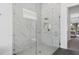 Glass enclosed shower with a rainfall showerhead, white marble tile, and a decorative built in niche at 1526 Euston Dr, Reunion, FL 34747