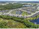 Aerial view of a residential community featuring houses surrounding a lake at 17676 Passionflower Cir, Clermont, FL 34714