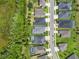 Aerial view of homes along a street, some featuring pools and solar panels near a green area at 17676 Passionflower Cir, Clermont, FL 34714