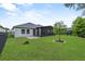 A lush green backyard features a screened in porch, mature trees, and a dark metal fence at 17676 Passionflower Cir, Clermont, FL 34714