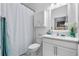 Clean bathroom featuring a vanity, toilet, shower with patterned curtain, and fresh white cabinets at 17676 Passionflower Cir, Clermont, FL 34714