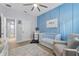 Bright Bedroom with a blue accent wall, crib, comfortable chair, and ample storage at 17676 Passionflower Cir, Clermont, FL 34714