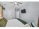Cozy bedroom with a TV, ceiling fan, and ample natural light from the windows at 17676 Passionflower Cir, Clermont, FL 34714