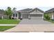 Charming single-story home featuring a two-car garage, well-maintained lawn, and inviting curb appeal at 17676 Passionflower Cir, Clermont, FL 34714