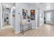 Bright hallway featuring light wood floors, modern decor, and access to various rooms in the home at 17676 Passionflower Cir, Clermont, FL 34714