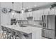 Modern kitchen with stainless steel appliances, white cabinetry, a large island with seating, and pendant lighting at 17676 Passionflower Cir, Clermont, FL 34714
