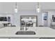 Close-up of the kitchen island with a sink, modern faucet, and stylish pendant lights above at 17676 Passionflower Cir, Clermont, FL 34714