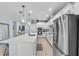 Bright kitchen with white cabinetry, a large island with seating, stainless steel appliances, and stylish pendant lighting at 17676 Passionflower Cir, Clermont, FL 34714