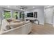 Bright living room features a large sectional sofa, ceiling fan, and natural light from the large picture window at 17676 Passionflower Cir, Clermont, FL 34714