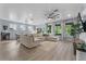 Open-concept living room featuring a sectional sofa, large windows, and seamless flow to the dining area at 17676 Passionflower Cir, Clermont, FL 34714