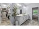Modern bathroom with double sinks, stylish fixtures, and access to a large walk-in closet; olive tree present at 17676 Passionflower Cir, Clermont, FL 34714