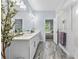 Bathroom boasts double sinks, a walk-in shower, and a view into an adjacent bedroom; decorative plant present at 17676 Passionflower Cir, Clermont, FL 34714