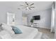 Bedroom boasts ensuite bathroom access and a wall-mounted television; plant and storage shelf present at 17676 Passionflower Cir, Clermont, FL 34714