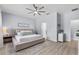 Comfortable bedroom boasts a neutral color palette, ceiling fan, and wood-look flooring; adjacent bathroom and closet doors at 17676 Passionflower Cir, Clermont, FL 34714