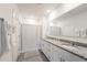 Bathroom featuring double sinks, granite countertops, and a shower with patterned shower curtain at 1792 Bull Hill Rd, Kissimmee, FL 34744