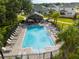 Community pool with lounge chairs, tables, umbrellas, and a covered eating area at 1792 Bull Hill Rd, Kissimmee, FL 34744