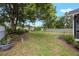 A large, grassy backyard offers ample space for outdoor activities and relaxation, framed by mature trees at 2101 Lily Ct, Sanford, FL 32771