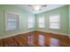 Inviting bedroom featuring wood floors, a ceiling fan, and three sun-filled windows at 2101 Lily Ct, Sanford, FL 32771