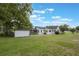 Exterior shot of the house from the rear with a screened porch, green grass, and shed at 2101 Lily Ct, Sanford, FL 32771