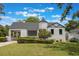 Beautifully landscaped front exterior with a striking red door, lush green lawn and well-manicured bushes at 2101 Lily Ct, Sanford, FL 32771