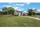 Inviting white home with a red front door, a lush lawn, and mature landscaping at 2101 Lily Ct, Sanford, FL 32771