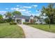 Charming Tudor-style home features a turret, red front door, and well-maintained landscaping at 2101 Lily Ct, Sanford, FL 32771