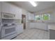 Well-lit white kitchen with updated appliances, lots of natural light, and tile flooring at 2101 Lily Ct, Sanford, FL 32771