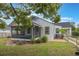View of the home's rear exterior, featuring a screened porch and established landscaping at 2101 Lily Ct, Sanford, FL 32771