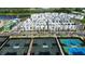 Aerial view showcases modern townhouses next to community tennis courts and manicured landscaping in a residential neighborhood at 2296 Brix Sts, Orlando, FL 32804